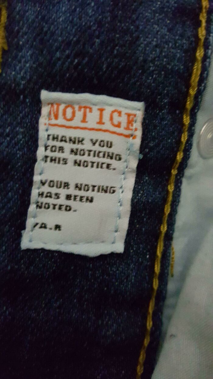 Small fabric label on denim with a funny pointless notice thanking for noticing the notice and noting the noting.
