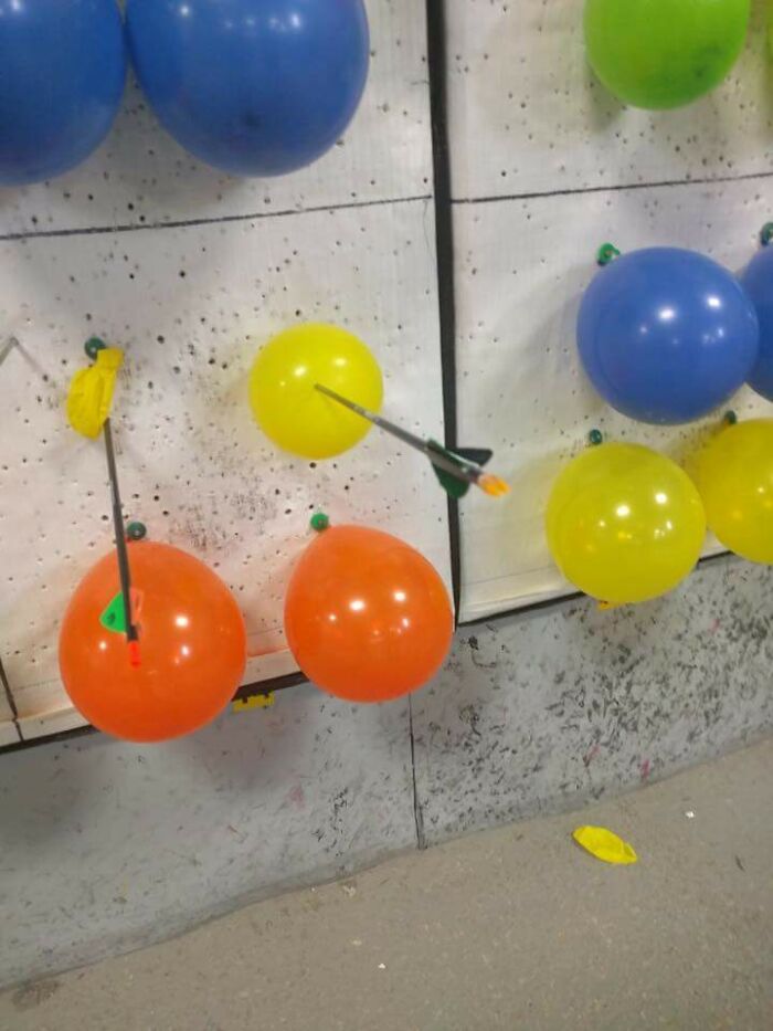 Colorful balloons stuck with arrows during archery, illustrating pointless things that serve no useful purpose but are funny.