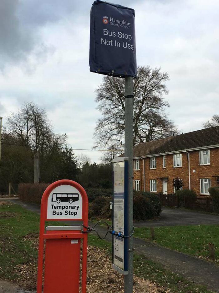 Temporary bus stop sign next to covered permanent stop, illustrating pointless things that serve no purpose except being funny.