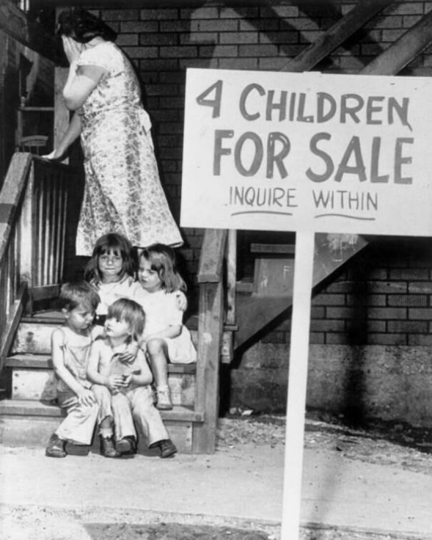 Black and white vintage photo showing four children sitting on stairs beside a sign for sale, illustrating random pictures.