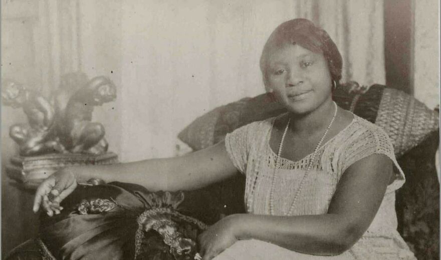 Vintage black and white photo of a woman seated indoors, part of a collection of random pictures worth going down a rabbit hole for.
