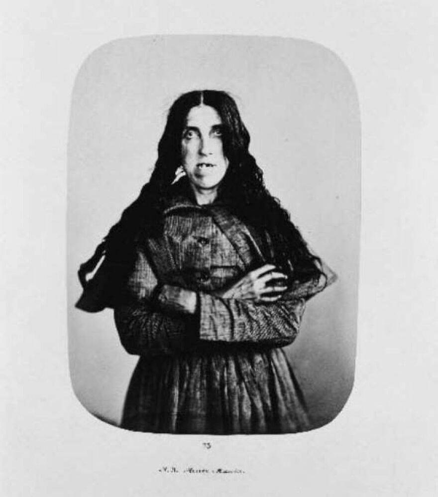 Vintage black and white portrait of a woman with long hair in a dress, one of the random pictures worth going down a rabbit hole for