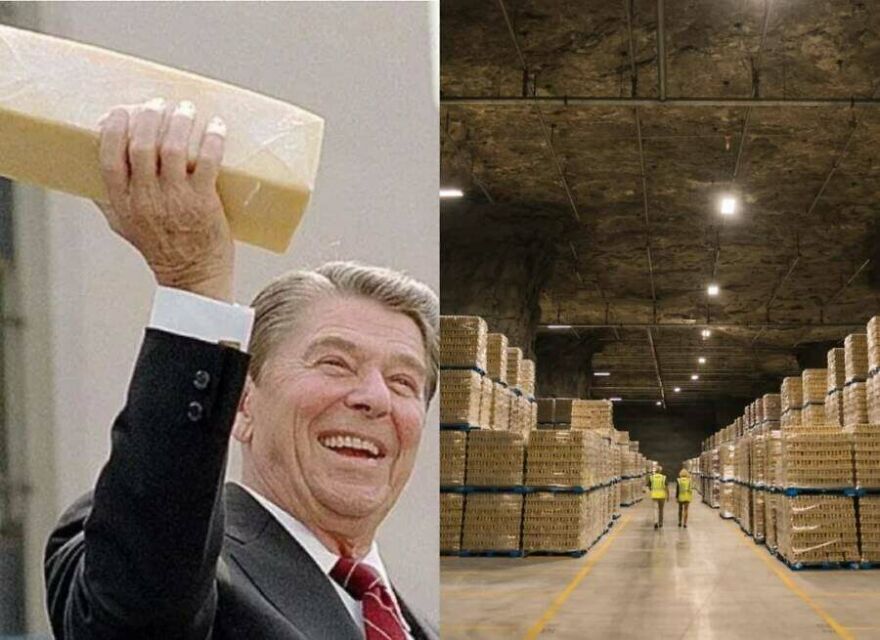 Smiling man holding large gold bar next to underground warehouse filled with stacked gold bars, a random picture worth exploring.