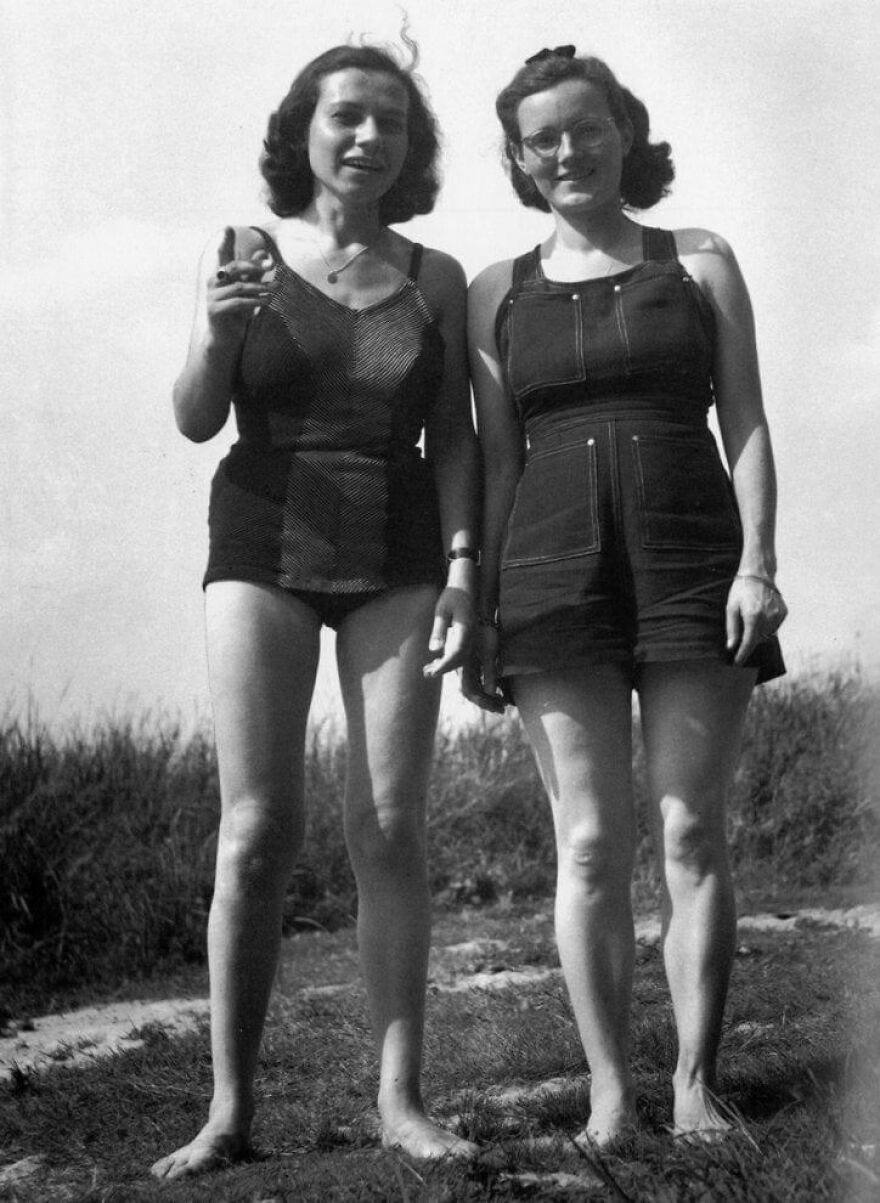Two women in vintage swimsuits standing outdoors on grass, a random picture worth going down a rabbit hole for.