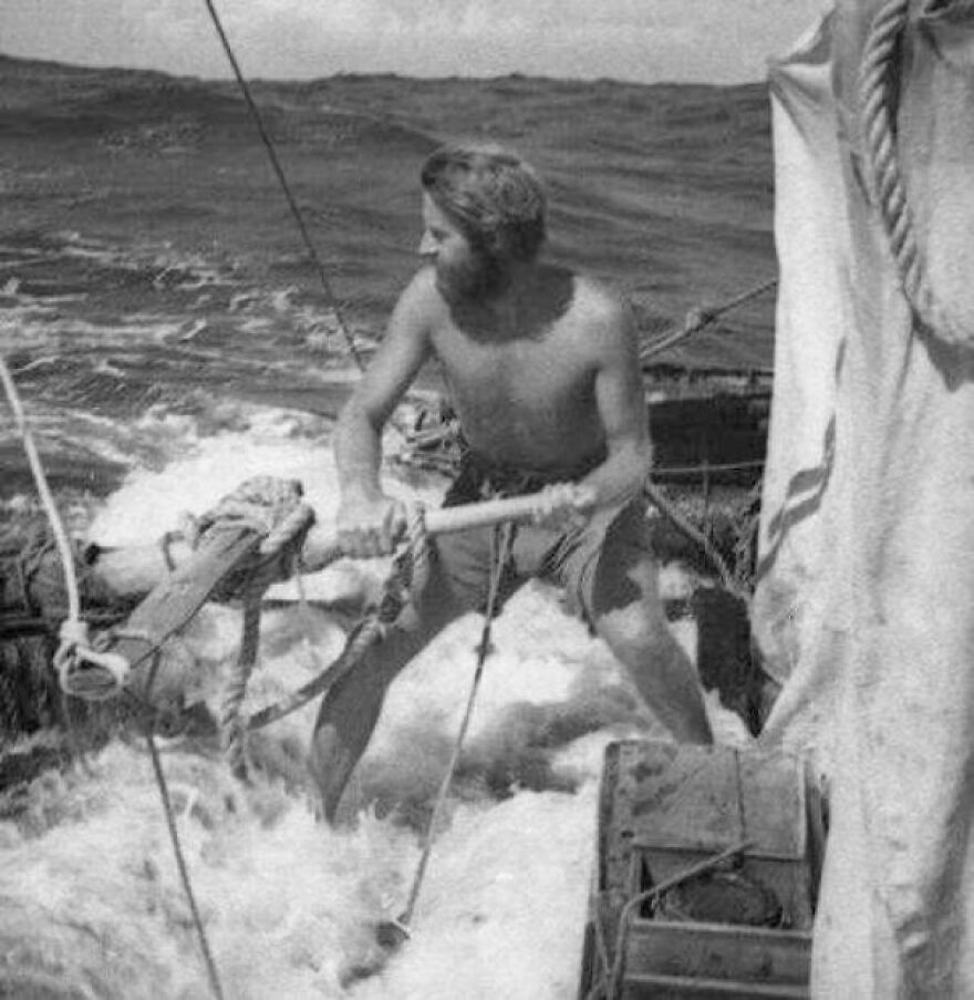 Man steering a small wooden boat on rough ocean waves in a vintage black and white photo, random pictures rabbit hole