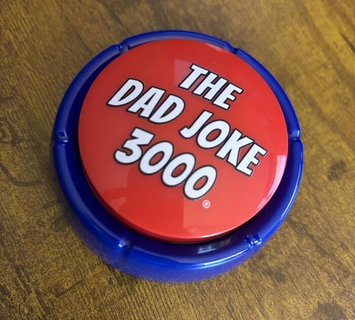The Dad Joke 3000 button gag gift on a wooden table, a humorous present for friends who love funny jokes.