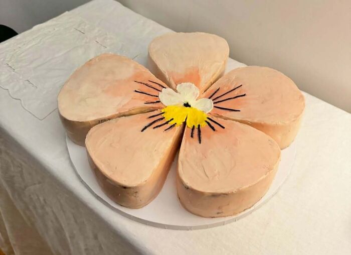 Flower-shaped cake with delicate pastel frosting showcasing masterfully crafted cakes and creative baking skills.