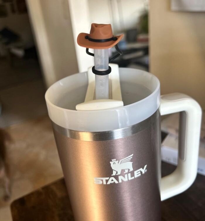 Stanley insulated mug with a novelty straw topper shaped like a cowboy hat, perfect gag gift idea for friends.