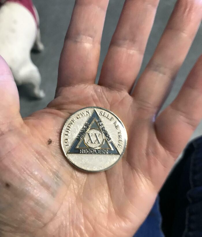 A hand holding a recovery medallion symbolizing a leap of faith and making the best life decisions.