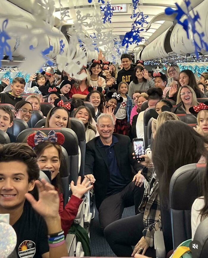 Group of happy people smiling and waving inside a decorated airplane, capturing a heartwarming moment of connection and joy.