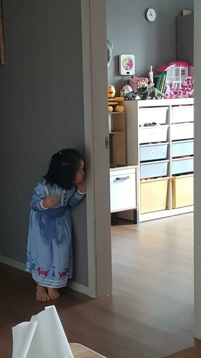 Little girl playing peekaboo and smiling in a heartwarming photo that will make your whole day feel lighter