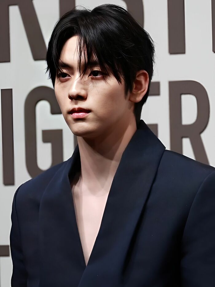 Soobin in a navy blazer at a formal event, showcasing his polished look and career highlights.