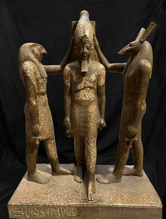 Ancient Egypt statue showing a pharaoh flanked by gods with animal heads, highlighting incredible historical craftsmanship.