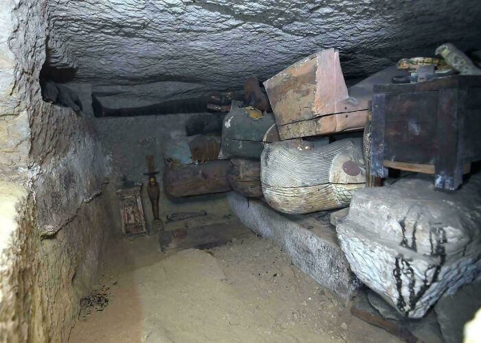 Ancient Egypt burial chamber with sarcophagi and artifacts revealing insights into historical burial practices.