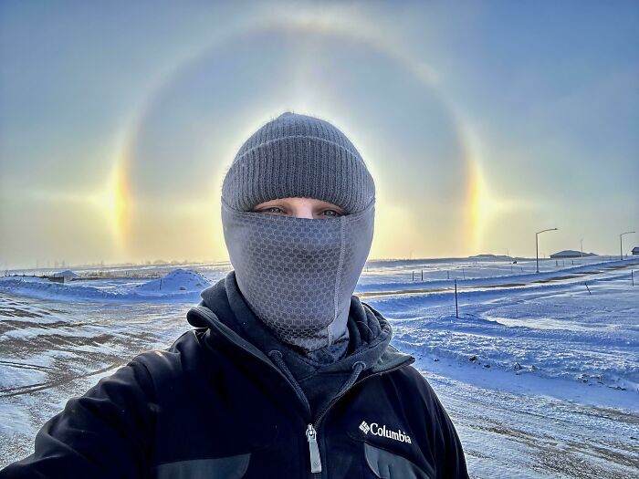 Person bundled up in winter gear outdoors with a rare sun halo phenomenon, showcasing unique moments from different jobs.