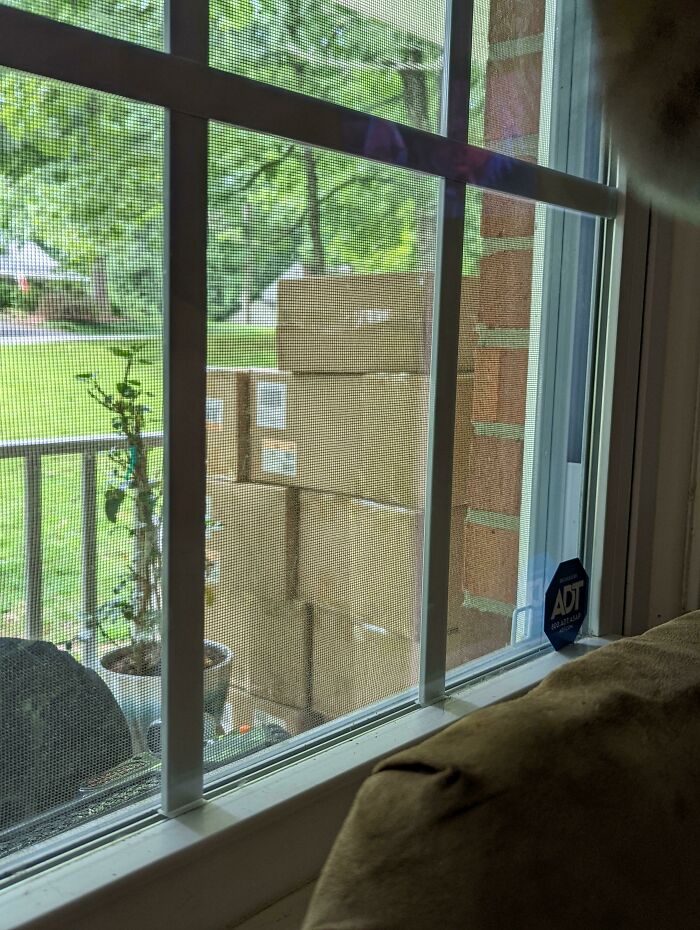 Several cardboard boxes stacked outside a home window, illustrating different jobs that make a 9-to-5 more bearable.
