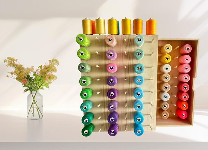Colorful sewing threads organized on a wooden rack, perfect gifts to make your mother-in-law impressed by your creativity.