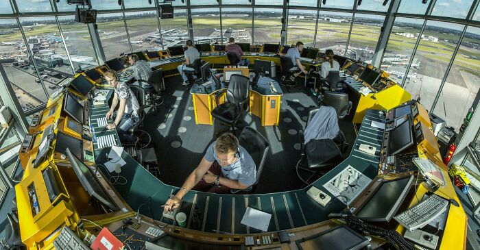 Air traffic controllers working in a high-tech control tower, showcasing unique jobs that make a 9-to-5 more bearable.