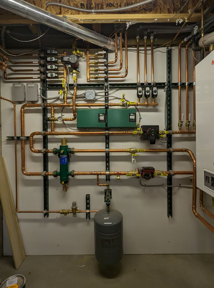 Intricate plumbing system with copper pipes and valves in a professional setup from different jobs making 9-to-5 bearable.