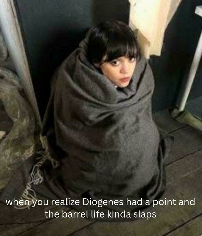 Person wrapped in a blanket sitting on the floor, reflecting on intellectual philosophy memes about Diogenes and barrel life.