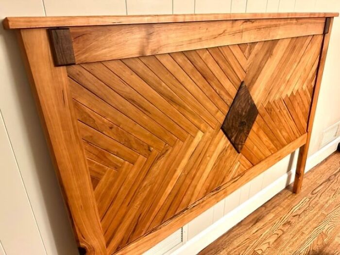 Intricately carved wooden headboard featuring geometric patterns showcasing skilled woodworking craftsmanship and design.