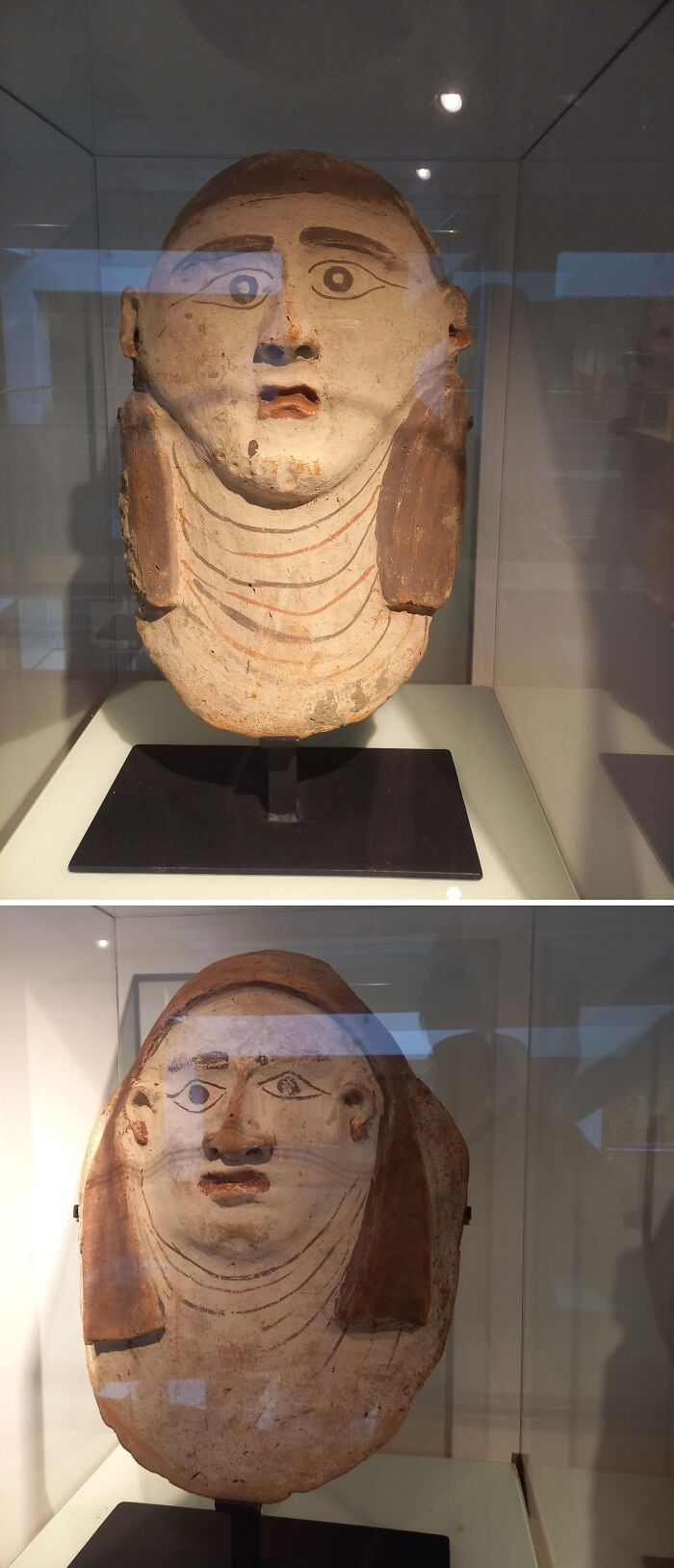 Painted ancient Egyptian funerary masks displayed in a museum showcasing artifacts from ancient Egypt.