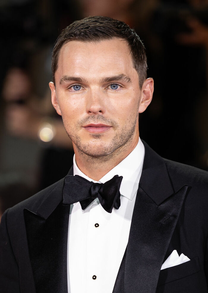 Nicholas Hoult in a black tuxedo with bow tie at a formal event, highlighting his bio and career highlights.
