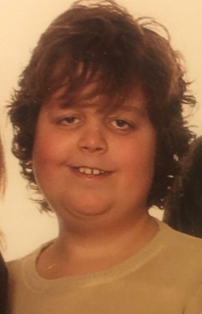 Awkward childhood photo of a smiling boy with messy hair, capturing a hilariously awkward moment from youth.