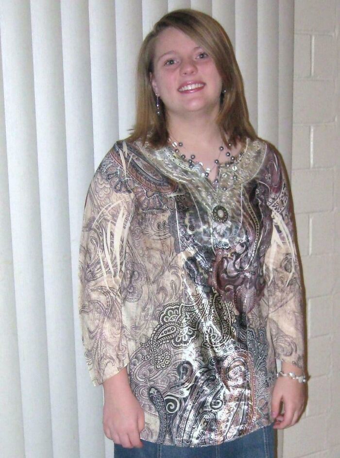 Smiling young woman in vintage patterned blouse and necklace, a classic example of hilariously awkward childhood photos.
