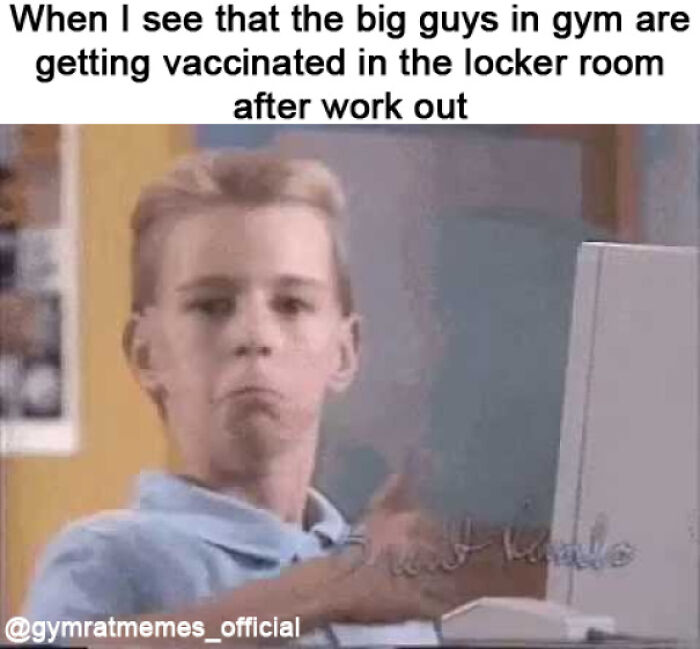 Young man at computer making a surprised face, relatable gym meme about big guys getting vaccinated after workout.