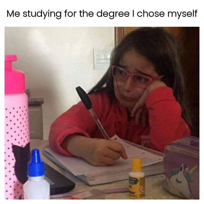 Tired student with glasses studying at a desk, surrounded by school supplies, representing college student struggle and hope.