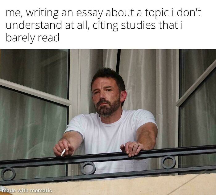 Man in a white shirt looking tired and stressed while writing, reflecting college memes for students running on hope and energy drinks.