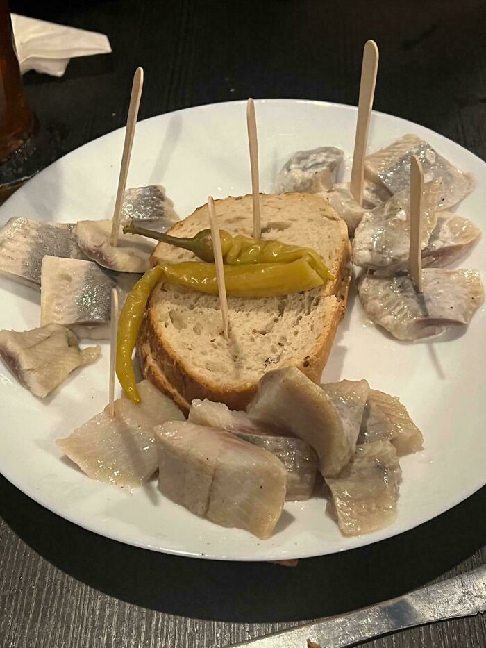 Plate of fish pieces and bread with peppers, an example of outrageous meals that look nothing like the menu photos.