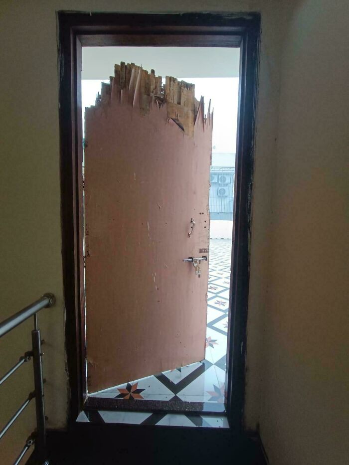 Worn-out rental door with damaged top edge and poor construction, showing a rental nightmare landlords tried to cut corners on.