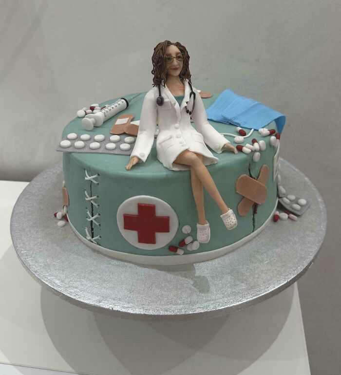 Cake featuring a detailed edible figure of a female doctor with medical-themed decorations, showcasing masterfully crafted cakes.