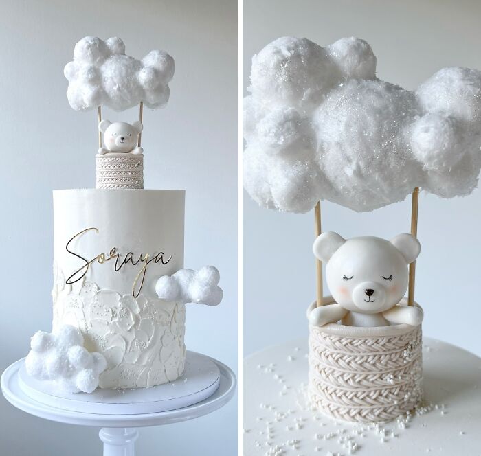 Elegant white cake featuring a bear in a woven basket with fluffy cloud decorations, showcasing masterfully crafted cakes.