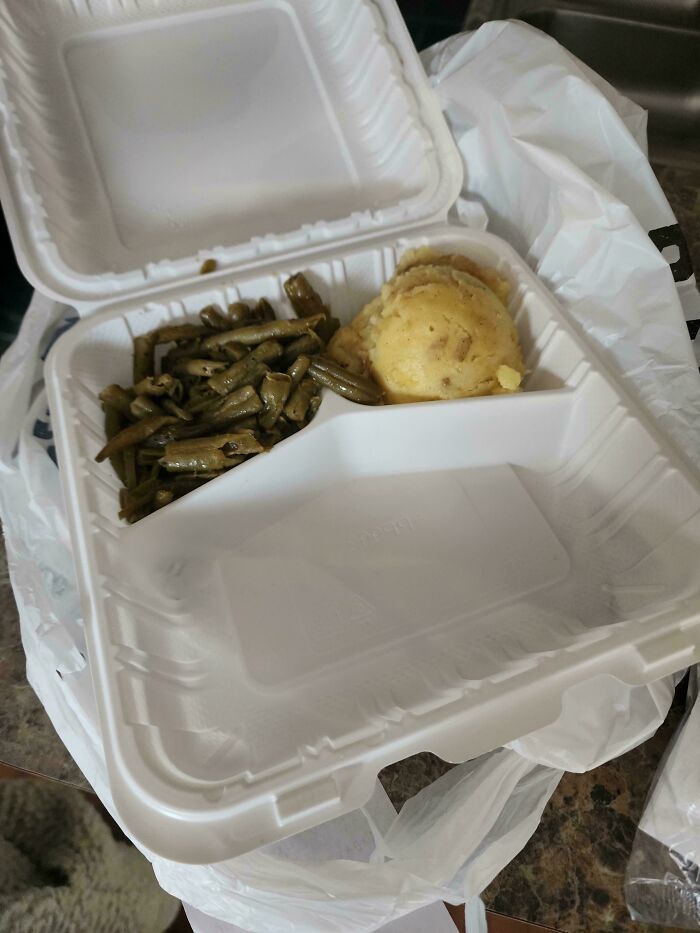 Takeout container with small portions of green beans and mashed potatoes showing outrageous meals that looked nothing like menu photos.