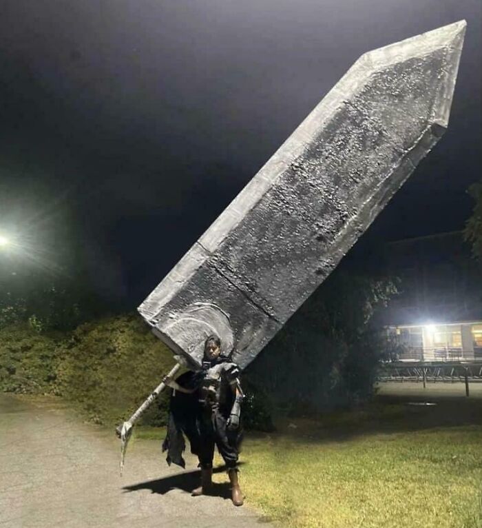 Person dressed in armor carrying an oversized sword outdoors at night, showcasing a weird math problem solution concept.