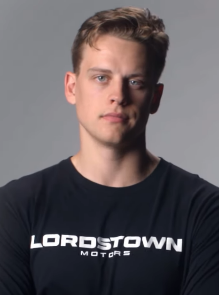 Young man with light brown hair wearing a black Lordstown Motors shirt, representing Joe Burrow career highlights.