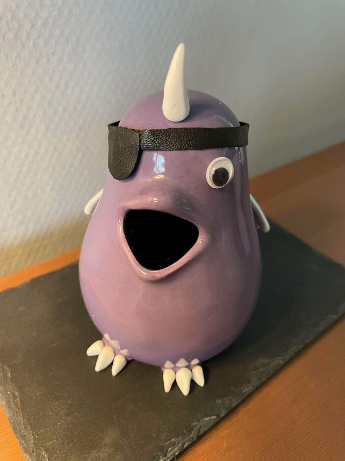 Purple ceramic bird with a unicorn horn and eye patch, a cool unexpected surprise found at a secondhand store.