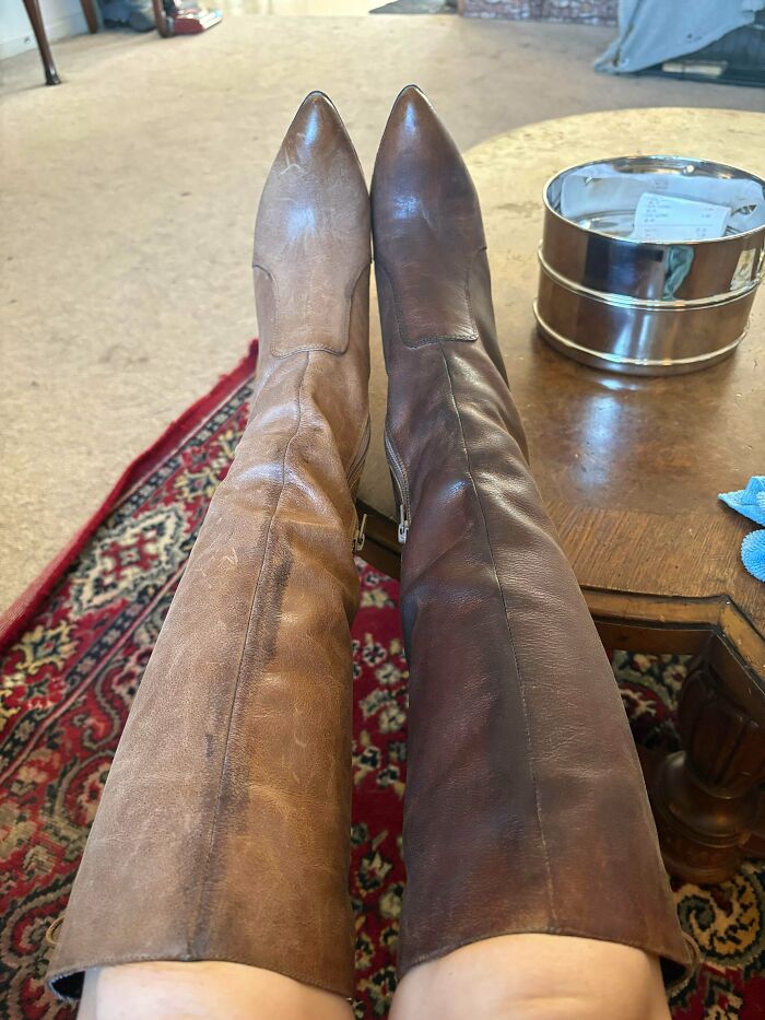 A pair of mismatched leather boots found at secondhand stores showing cool, unexpected surprises in footwear.