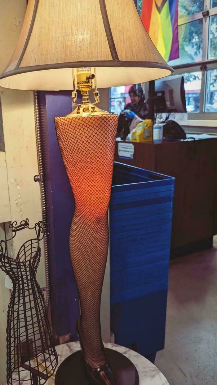 Lamp with a fishnet stocking covered leg base in a secondhand store offering cool, unexpected surprises.