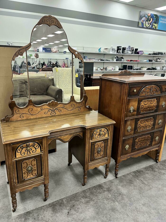 Vintage wooden vanity and dresser with intricate designs displayed in a secondhand store offering cool, unexpected surprises.