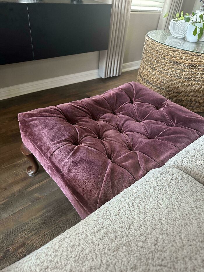 Plush purple tufted ottoman found at a secondhand store, showcasing cool and unexpected vintage furniture surprises.
