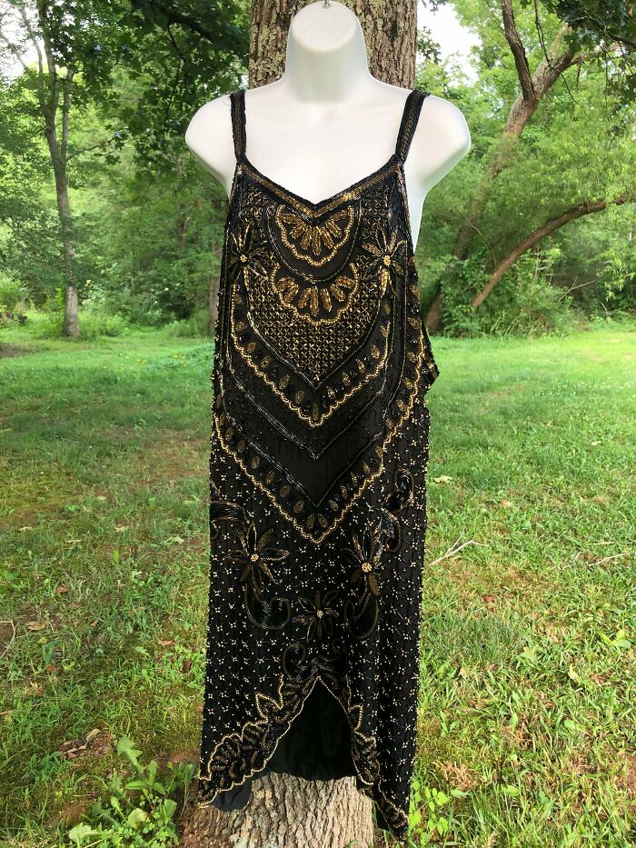 Black and gold embellished vintage dress displayed outdoors, showcasing secondhand stores cool unexpected surprises fashion find.