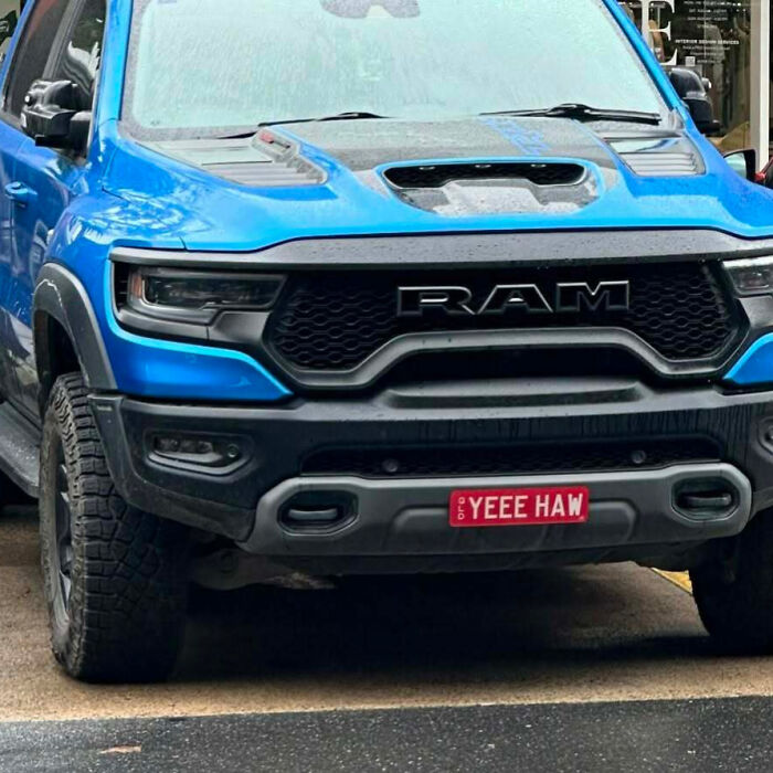 Blue RAM truck with a hilarious personalized license plate reading YEEE HAW, catching attention from strangers.