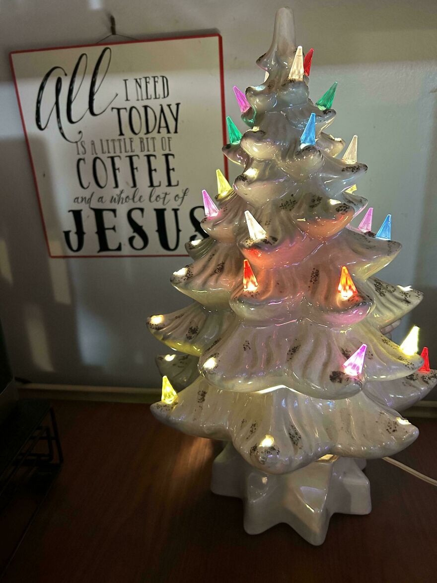 Ceramic vintage Christmas decoration shaped like a tree with multicolored lights glowing in a nostalgic style.