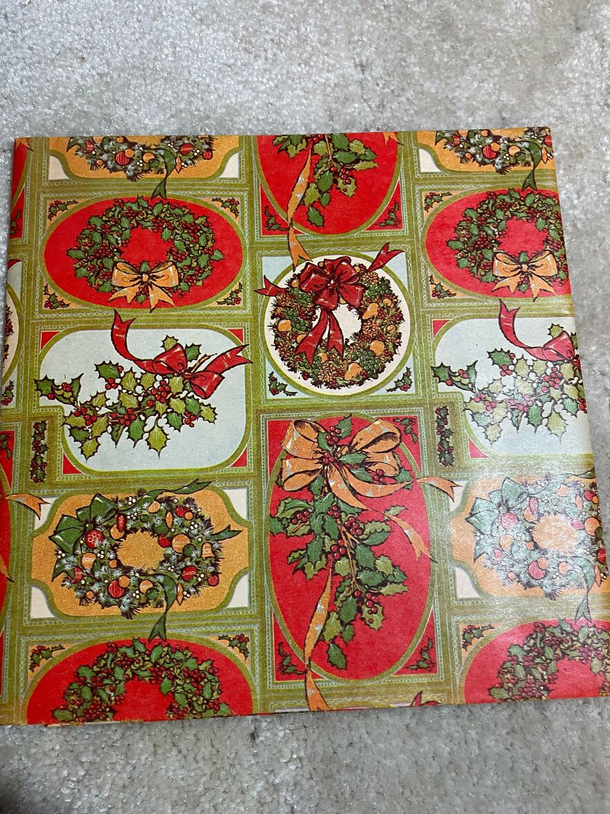 Vintage Christmas decorations featuring festive wreaths and holly with red and gold ribbons on a patterned background.