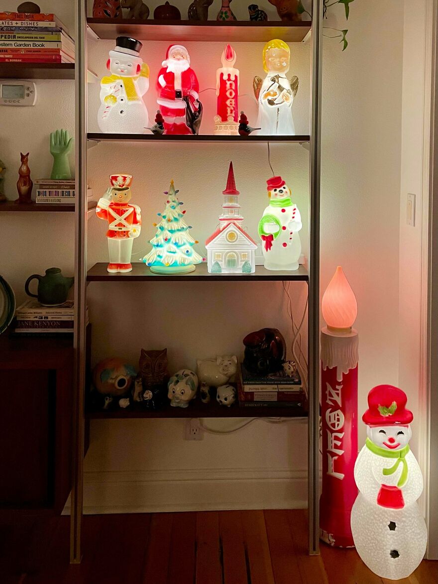Vintage Christmas decorations including light-up snowmen, Santa, nutcracker, and holiday-themed figurines on shelves and floor display.