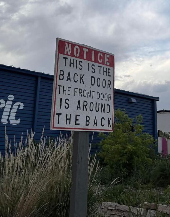 Funny meme showing a confusing notice sign about front and back doors on a cloudy day.